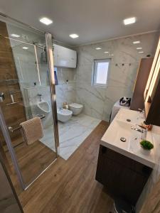 a bathroom with a shower and a toilet and a sink at Fisherman's Lounge in Izola +28 photos