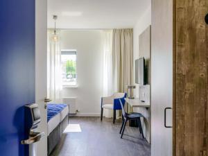 a bedroom with a bed and a desk and a table at ibis Styles Almere in Almere