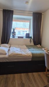 a bedroom with a large bed with a window at Cute Mini Studio in Kristiansand