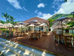 a deck with tables and chairs and umbrellas at Niva Labriz Seychelles in Silhouette Island
