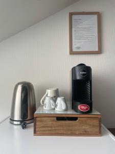 a coffeemaker and a coffee maker on a shelf at Auberge de la Charrue in Romanel-sur-Lausanne