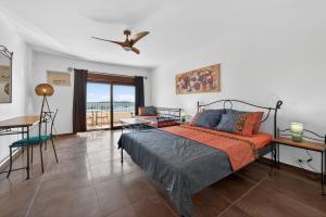 a bedroom with a bed and a table and a balcony at Villa Konstantina in Orasac +62 photos