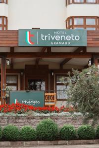 a hotel with a sign in front of a building at Hotel Triveneto Gramado in Gramado
