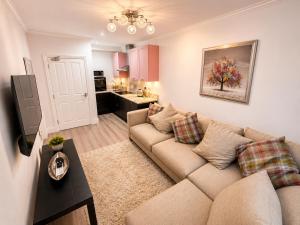 a living room with a couch and a kitchen at Corbridge Apartment in Corbridge