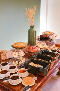 a table topped with lots of different types of food at Hotel Triveneto Gramado in Gramado