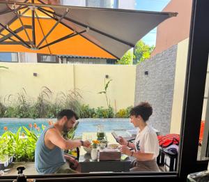 a man and woman sitting at a table with food at Maison De Hoi An Boutique Homestay in Hoi An