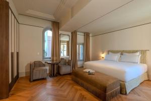 a hotel room with a large bed and a chair at Palazzo Genazzini in Bellagio