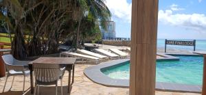a view of a swimming pool with chairs and a table at Game Fish Lodge in Nungwi