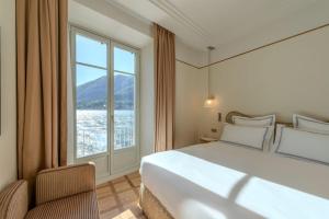 a bedroom with a large bed and a large window at Palazzo Genazzini in Bellagio