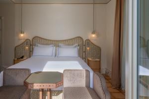 a bedroom with a bed with two chairs and a table at Palazzo Genazzini in Bellagio