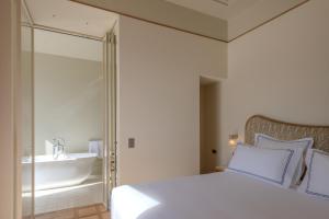 a bedroom with a bed and a bathroom with a sink at Palazzo Genazzini in Bellagio