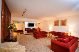 a living room with red couches and a television at Avari Lahore Hotel in Lahore