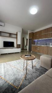 a living room with a table and a kitchen at Tale Coast Apartments in Tale