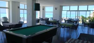 a pool table in a room with tables and chairs at Game Fish Lodge in Nungwi