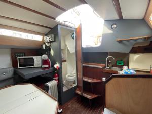 a small kitchen with a sink and a microwave at Voilier Miraflores in Cherbourg en Cotentin
