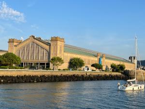 a boat in the water in front of a large building at Voilier Miraflores in Cherbourg en Cotentin