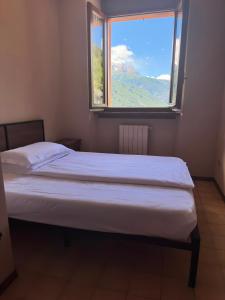 a bed in a room with a large window at Villa Luzzago in Ponte di Legno
