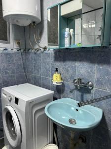 a bathroom with a sink and a washing machine at Stan na dan Čajniče in Čajniče +7 photos