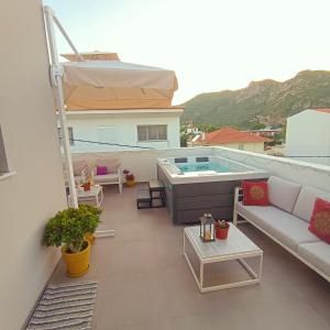 a rooftop patio with a hot tub on a building at Elegant Dream Suites in Agia Anna
