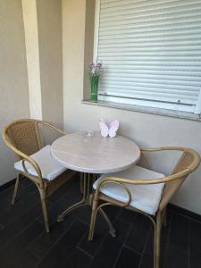 a table and chairs with a butterfly sitting on top of it at Apartman Moskva in Teslić +6 photos