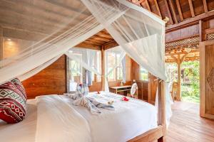 a bedroom with a white bed with a canopy at Green labak 2 in Silebeng