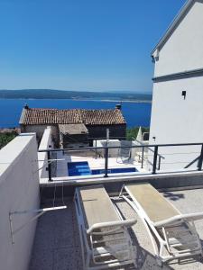 a balcony with chairs and a view of the water at Vila Ema Dramalj in Dramalj