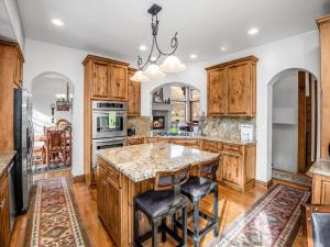 a kitchen with wooden cabinets and a large island with bar stools at Alpine Drive Chalet in Vail