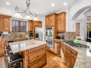 a kitchen with wooden cabinets and a large island at Alpine Drive Chalet in Vail