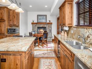 a kitchen with a table and a fireplace at Alpine Drive Chalet in Vail