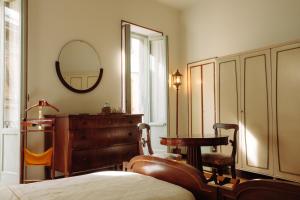 a bedroom with a bed and a dresser and a mirror at La casa del Ginkgo in Bobbio