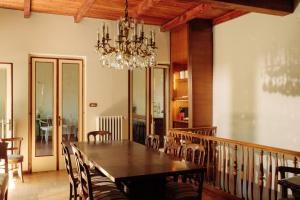 a dining room with a wooden table and a chandelier at La casa del Ginkgo in Bobbio