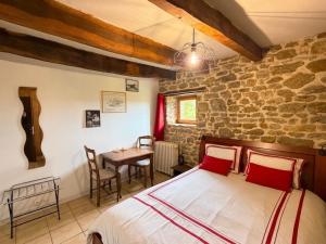 a bedroom with a bed and a table in a room at Chambres d'Hôtes du Manoir du Haut Salmon in Saint Malo