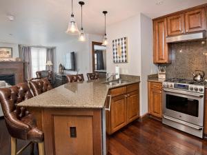 a kitchen with wooden cabinets and a counter top at Ascent Condo 111 in Avon