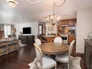 a kitchen and dining room with a wooden table and chairs at Ascent Condo 111 in Avon +22 photos