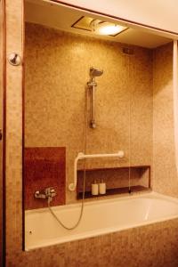 a bathroom with a bath tub with a shower at La casa del Ginkgo in Bobbio
