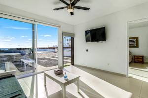 a living room with a ceiling fan and a tv at Dog-Friendly Oceanfront Villa with Rooftop Patio, Pool Access, & Kitchen in Rosarito