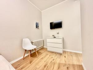 a bedroom with a chair and a tv on a wall at Alpine Escape 1BR Apartment A in Tarvisio