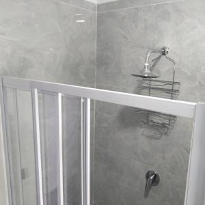 a bathroom with a shower with a sink and a faucet at Exclusive guest house in Modimolle