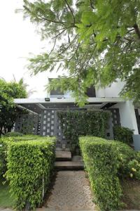 a building with green bushes in front of it at Tuệ House in Ấp Gia Thanh (1)