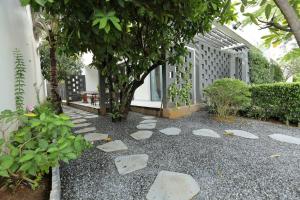 a garden with rocks on the ground in front of a building at Tuệ House in Ấp Gia Thanh (1)