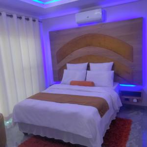 a bedroom with a large bed with purple lights at Exclusive guest house in Modimolle