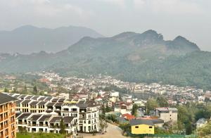 a city with buildings and mountains in the background at Jade's House Sapa - Stunning Views, 3BR, Kitchen & Washer, 5 Min to Town in Lao Cai