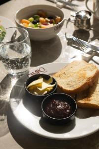 a plate of food with toast and a bowl of dips at Hotel San Valentino in Rome