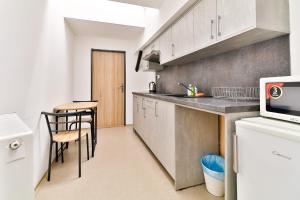 a kitchen with white cabinets and a table and chairs at Hostel u Arény in Ostrava