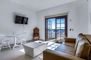 a living room with a couch and a table at Dog-Friendly Suite with Kitchenette, Heated Outdoor Pool, Hot Tub, Terrace, AC in Rosarito