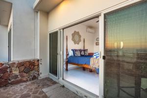 a bedroom with a bed and a glass door at Dog-Friendly Ocean-view Villa with Patio, Outdoor Pool, Streaming, partial AC in Rosarito +43 photos