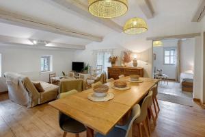 a living room with a wooden table and chairs at Le Mas de la Rode in Saumane