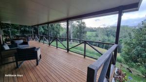 a large deck with a view of the woods at Bellthorpe Retreat in Bellthorpe