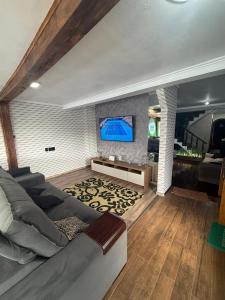 a living room with a couch and a flat screen tv at HOSTEL FAMILIA ZANATTA in Caxias do Sul