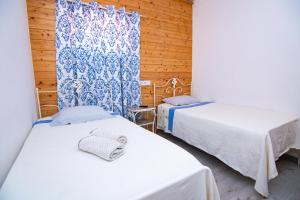 two beds in a room with wooden walls at Guest House D'Avenida in Vila Praia de Âncora